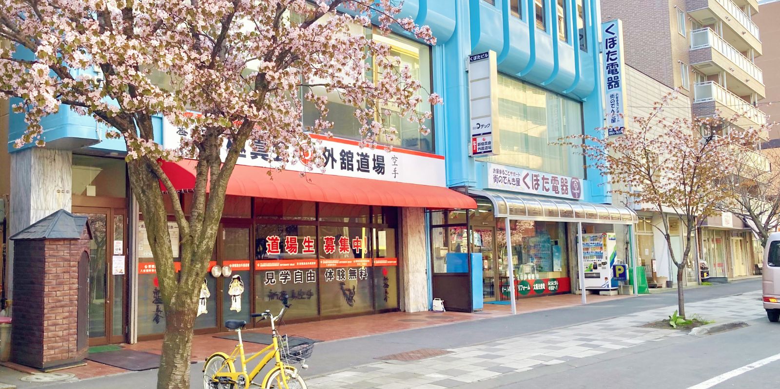 桜が咲く札幌市白石区本郷通の新極真会 外舘道場 本部道場の外観と入口