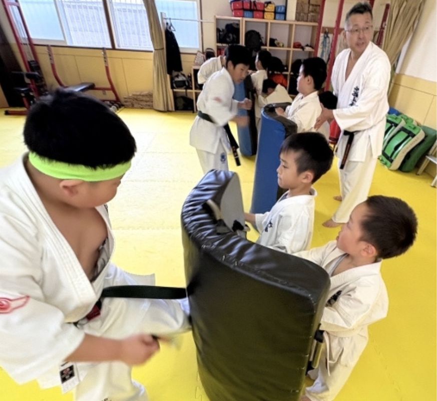 外舘道場で子どもたちが指導を受けながらミット打ちをしている様子